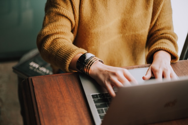 Person working on a laptop reviewing data and researching business information