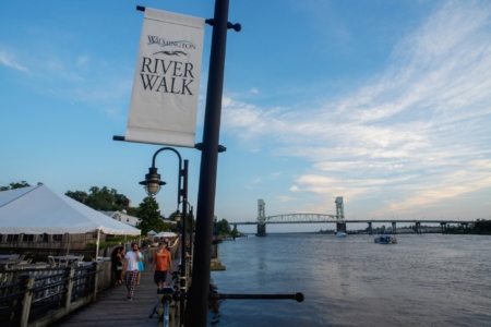 Wilmington Riverwalk along the Cape Fear River in downtown Wilmington, North Carolina, featuring waterfront views, local attractions, restaurants, shops, and the iconic riverfront boardwalk.