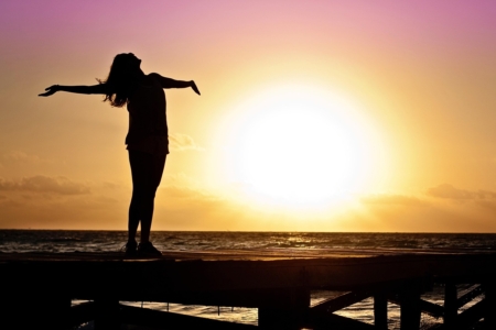 Woman enjoying the sunrise on the Carolina Beach boardwalk.